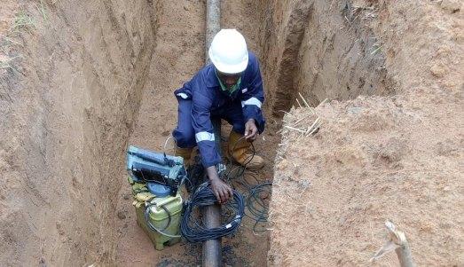 An MJD technician working in a shored excavation wearing full personal protective equipment