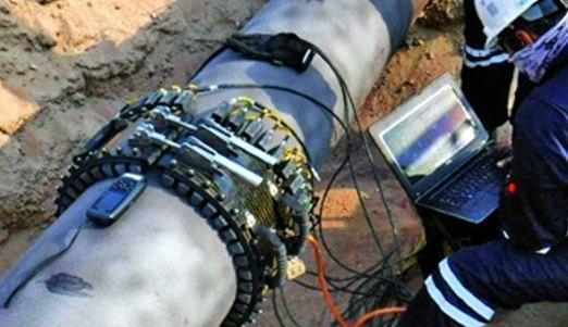 A technician taking long-range ultrasonic readings on a pipeline
